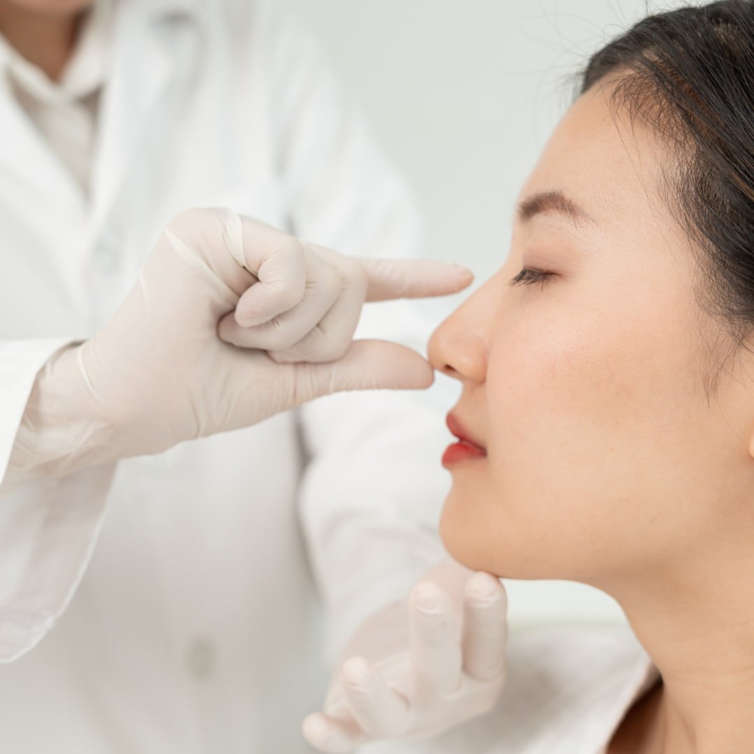 Dokter memeriksa hidung pasien saat konsultasi operasi hidung